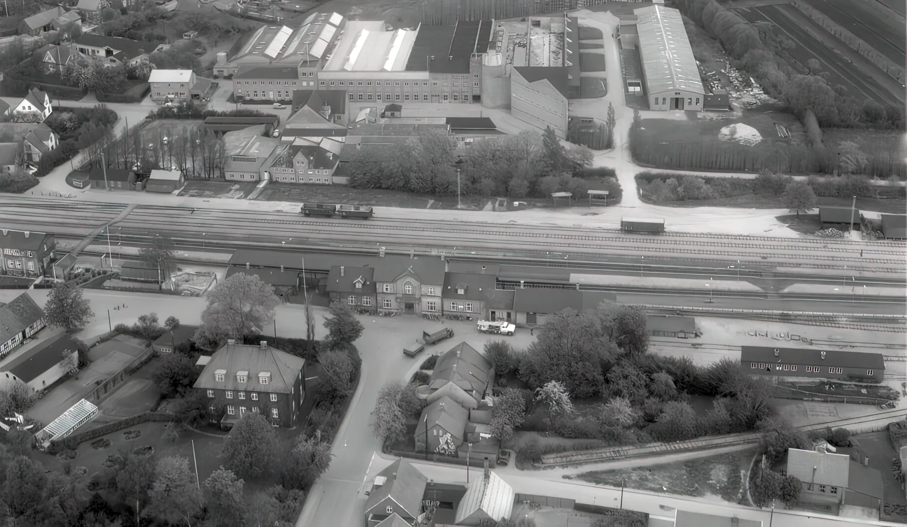 Billede af Tommerup Station (1865-1883) er placeret til venstre for midten og stationen fra 1883 i midten. Billede af Tommerup Station (1865-1883) er placeret til venstre for midten og stationen fra 1883 i midten.