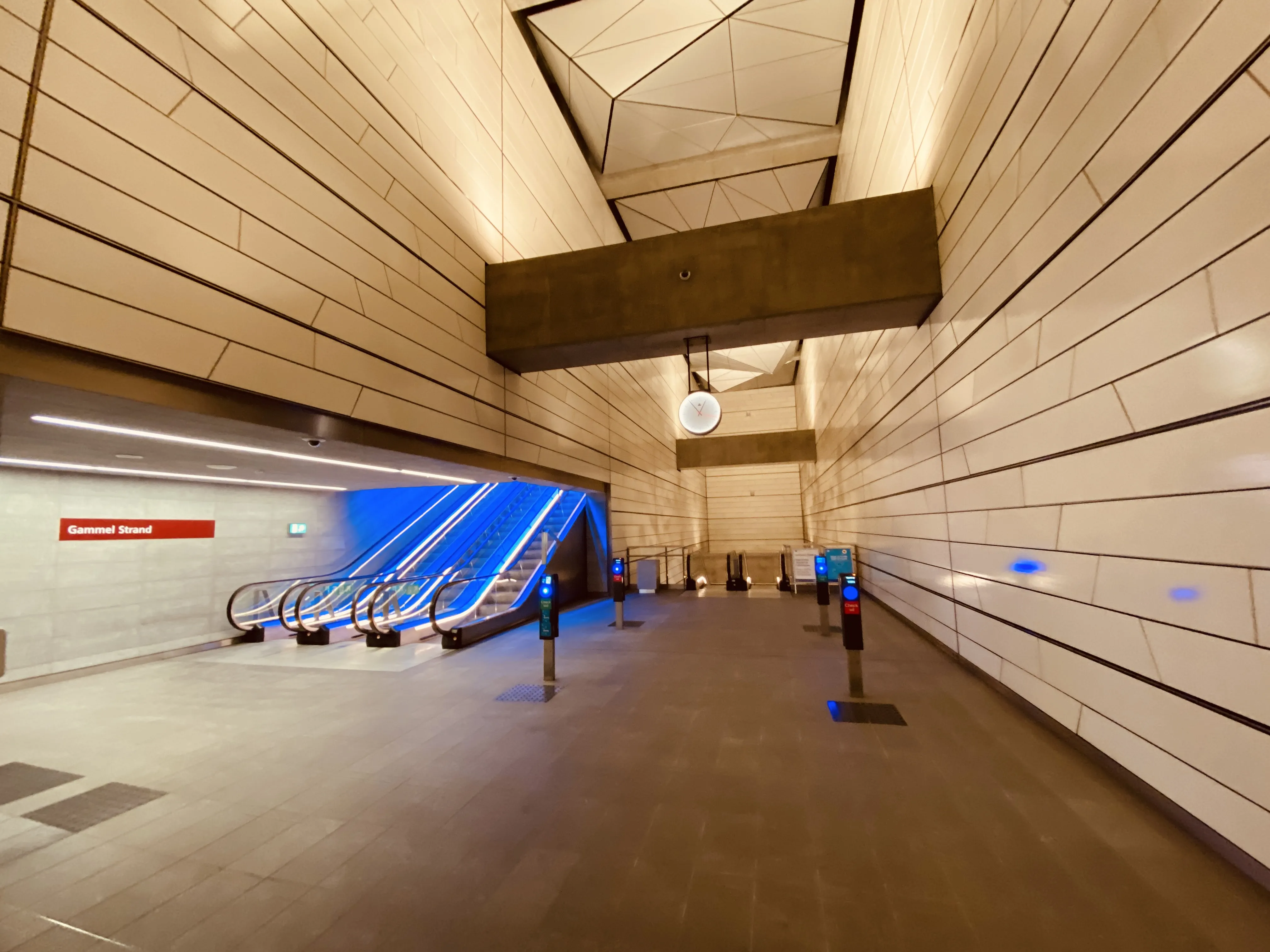 Billede af Gammel Strand Metrostation med et blåt lysspil, som er en hilsen til sollyset i vandoverfladen i Gammel Strands kanal, der løber lige ved siden af stationen. Billede af Gammel Strand Metrostation med et blåt lysspil, som er en hilsen til sollyset i vandoverfladen i Gammel Strands kanal, der løber lige ved siden af stationen.
