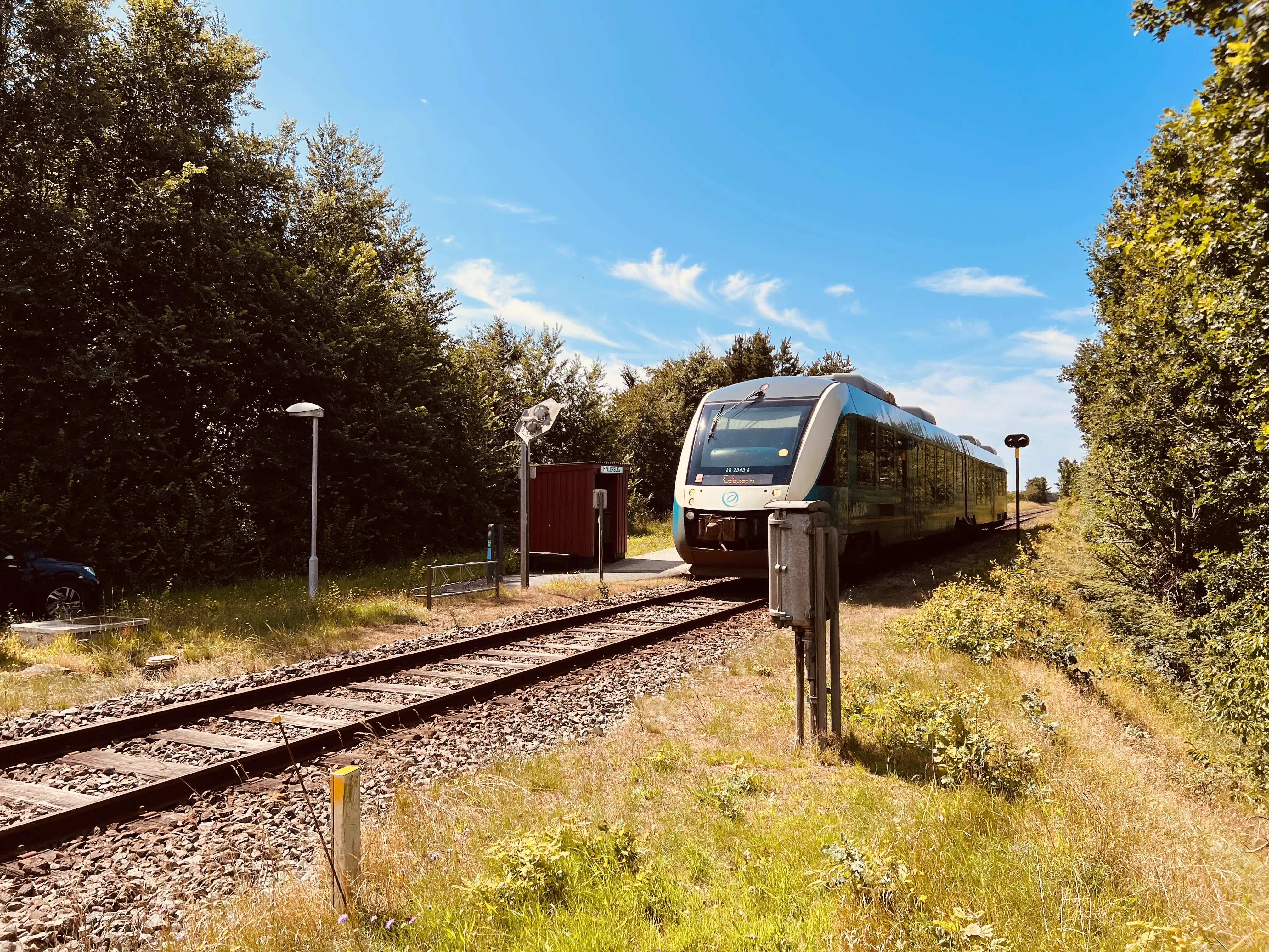 Billede af tog ud for Hyllerslev Trinbræt. Billede af tog ud for Hyllerslev Trinbræt.