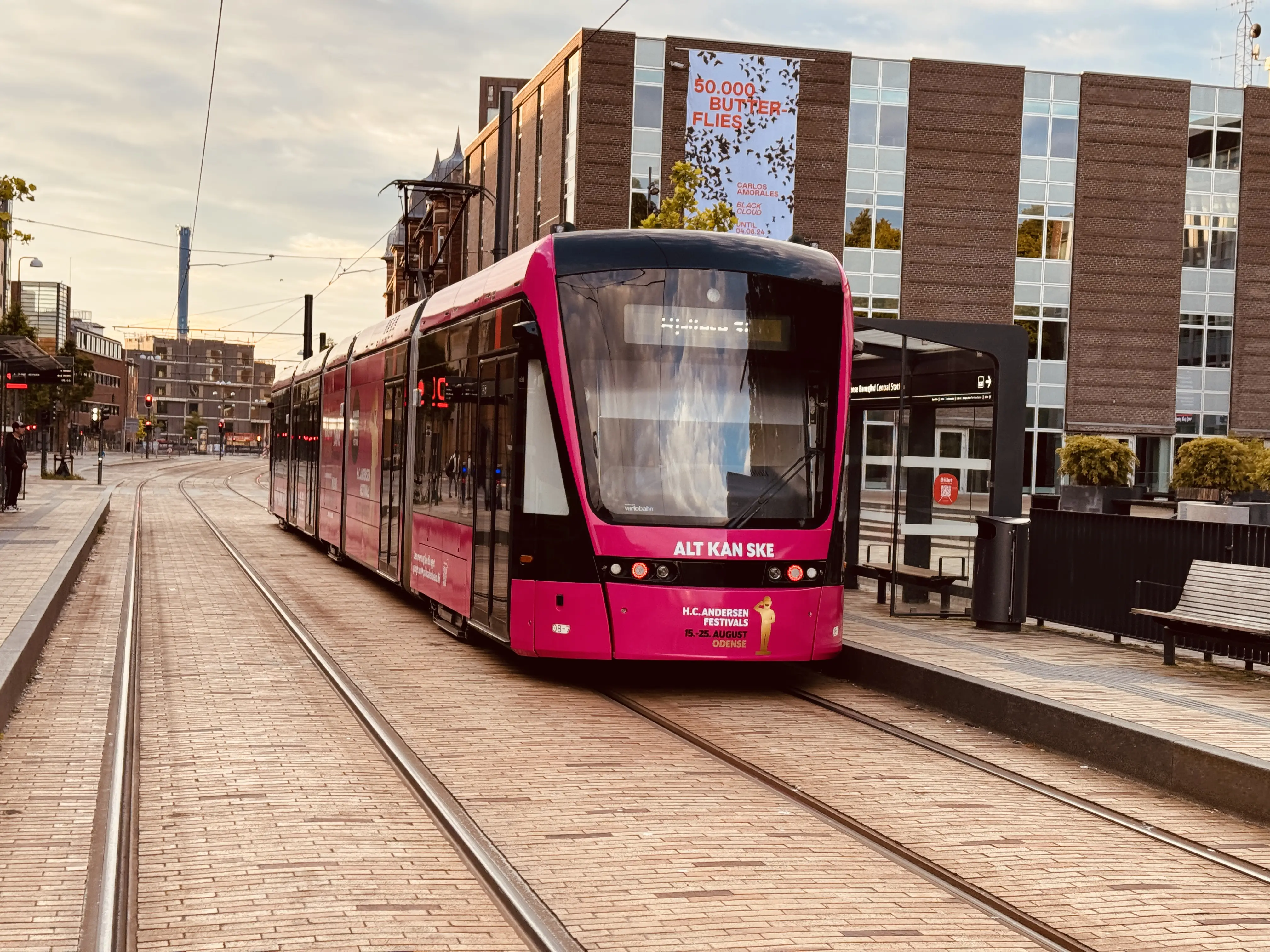 Billede af Odense Letbane togsæt 08, i H.C. Andersen Festivals udklædning, fotograferet ud for Odense Banegård Center. Billede af Odense Letbane togsæt 08, i H.C. Andersen Festivals udklædning, fotograferet ud for Odense Banegård Center.