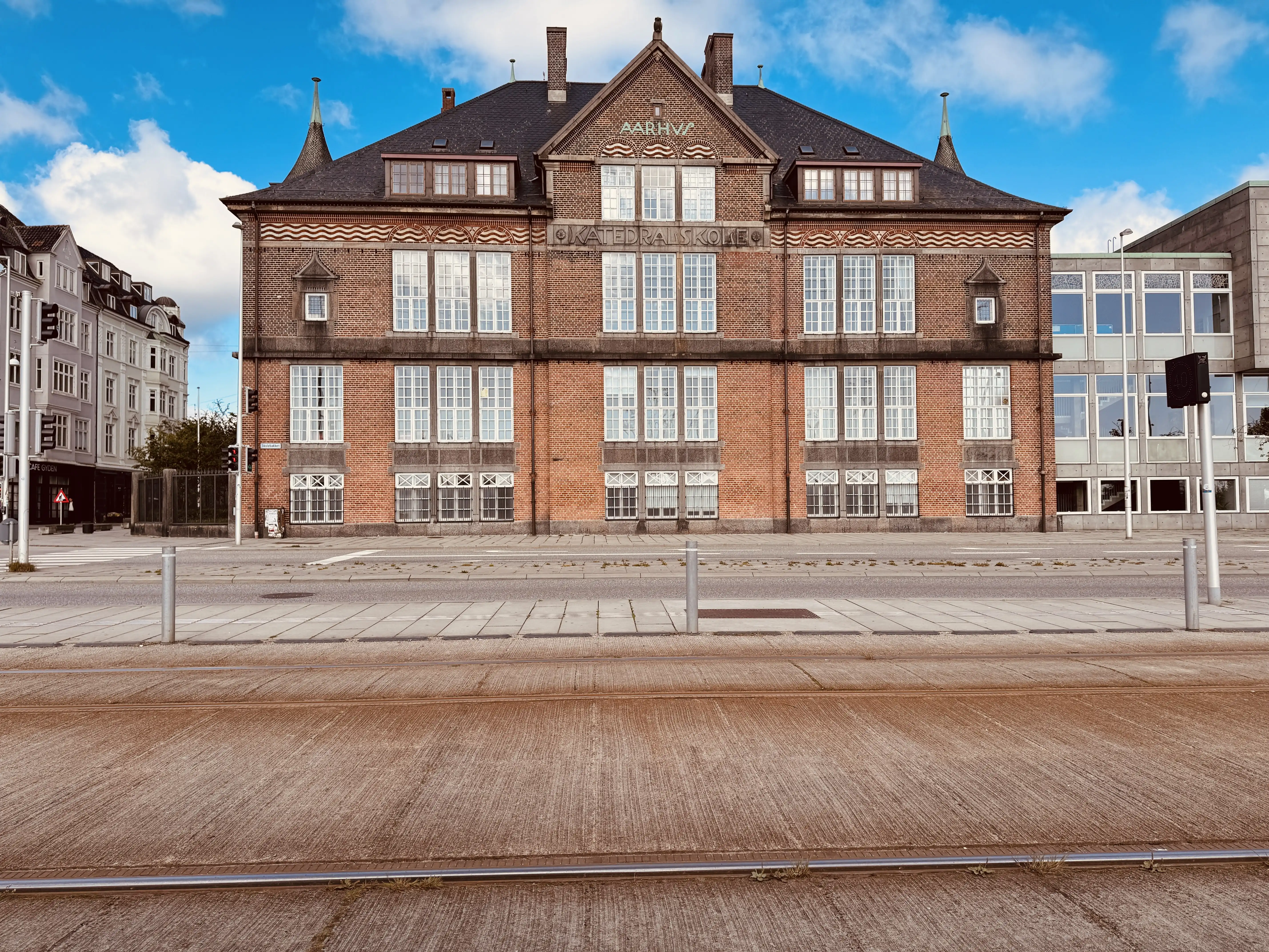 af Aarhus Katedralskole, som ligger over for Skolebakken Trinbræt og er årsagen til navnet Skolebakken for vejen og trinbrættet.